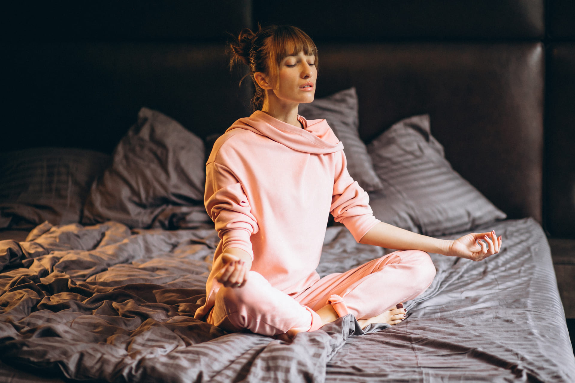 Mulher fazendo meditação na cama