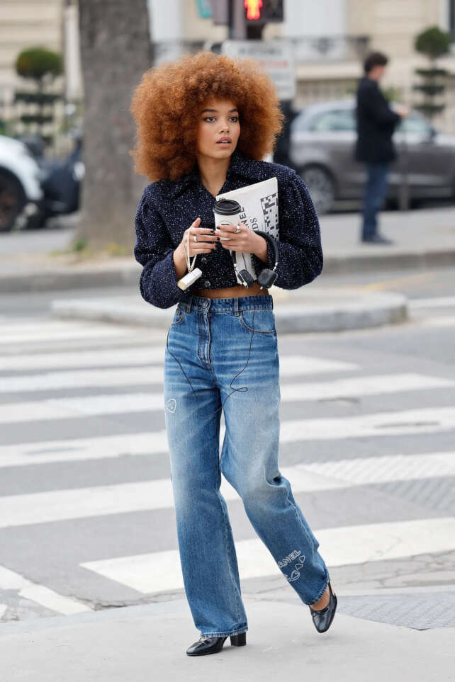 Mulher vestido jaqueta curta com calça flare e sapato de bico redondo.